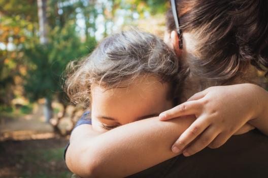 A young girl hugging someone