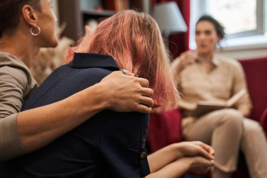 A woman with her arm around another woman 