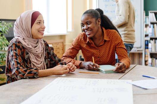 Two women sat a table smiling