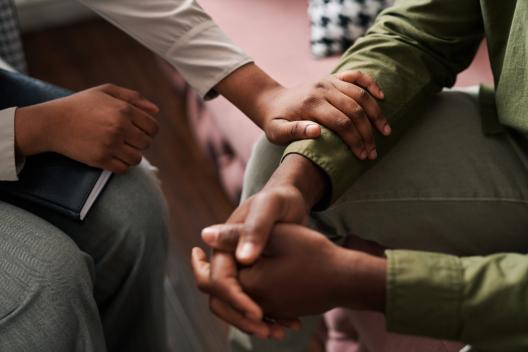Two people holding hands supportively