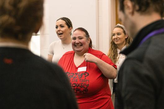 A woman in a red t-shirt at a workshop