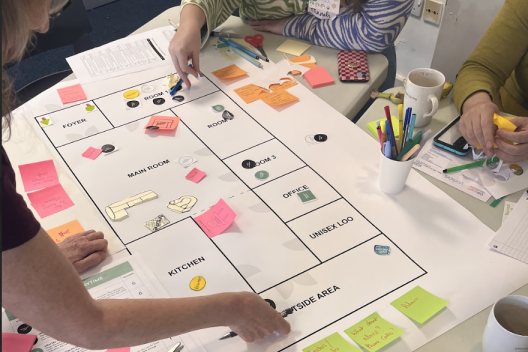 People designing the York Community Hub on paper with post its and pens