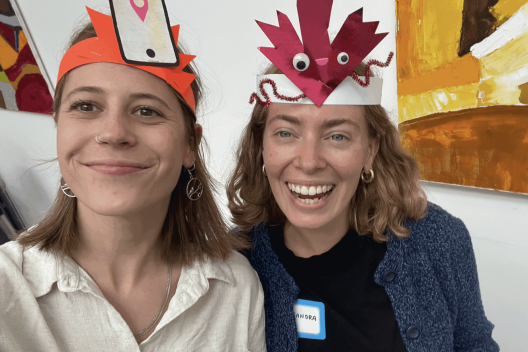 Savannah Fishel and Alessandra Tombazzi take a selfie. They are wearing paper hats