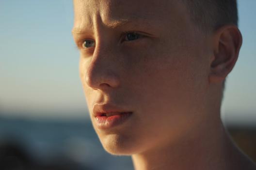 A 12 year old boy looking into the sun