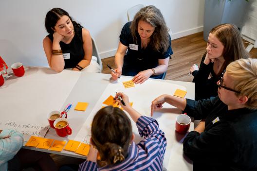 The innovation unit team work at a table with a big piece of paper