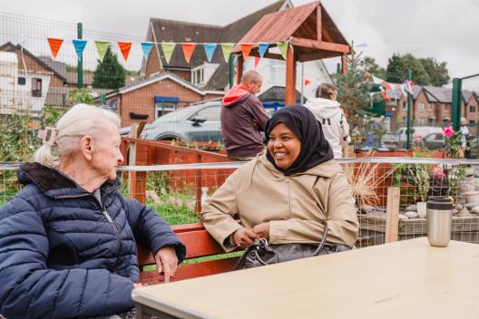 Two people at Ridge Hill, Tameside talking in a community garden