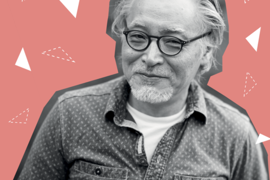 An older Asian man smiles at the camera