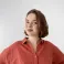 Bethan smiling at the camera. She's a white woman with short brown, wearing a red shirt.