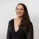 Hannah smiling at the camera. She's a white woman with long brunette hair, wearing a black dress