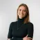 Rachel smiling at the camera. She's a white woman with shoulder length hair, wearing a black turtle neck
