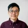 Yin Hei Ho looking at the camera. He is wearing glasses and a burgundy shirt.