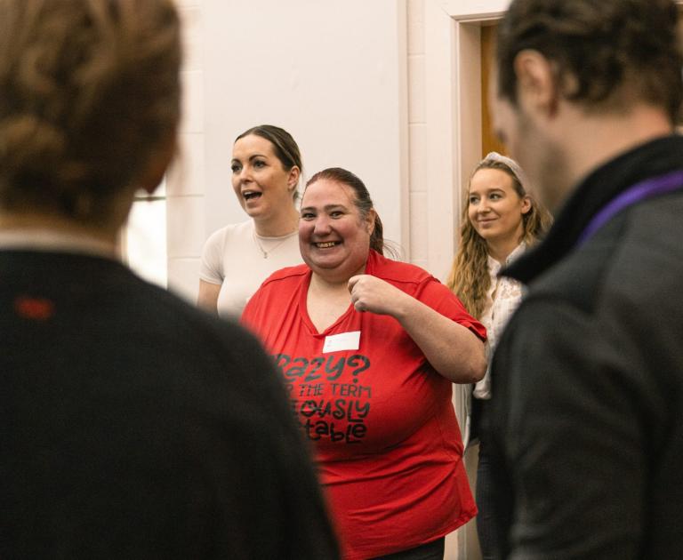 A woman in a red t-shirt at a workshop