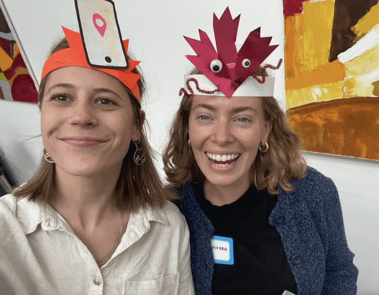 Savannah Fishel and Alessandra Tombazzi take a selfie. They are wearing paper hats