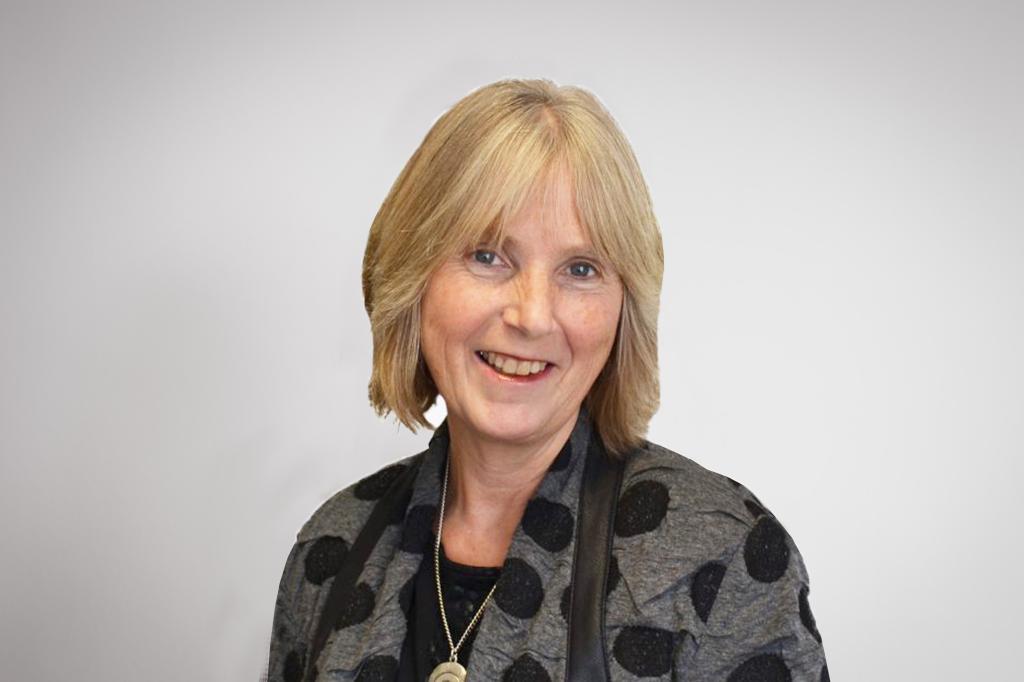 Frances smiling at the camera. She's a white woman with short blonde hair, wearing a grey and black jacket