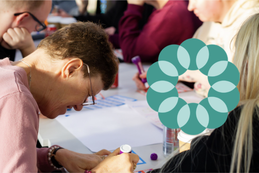 A woman writing on a piece of paper, with the Live Well logo next to her
