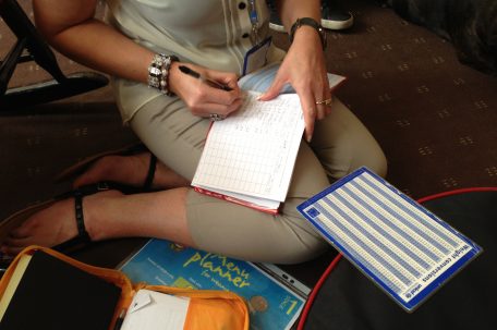 Female writing in food diary on floor of living room