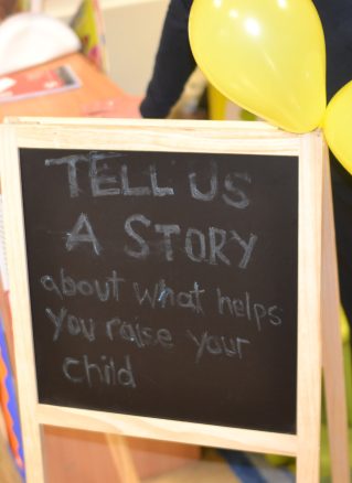 Community engagement sign 'tell us a story about what helps you raise your child'