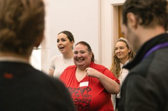 A woman in a red top smiling