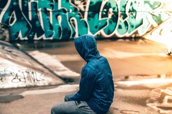 Young man near graffiti wall