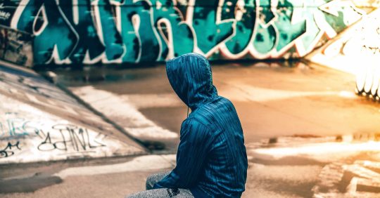 Young man near graffiti wall