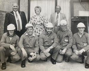 Newspaper clipping image of group of men kneeling thought to be from South Wales Argus 1990